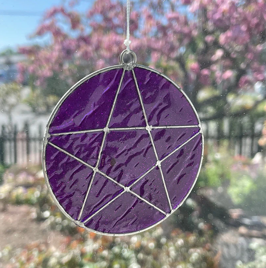 The Mystical Pentagram Suncatcher is a great choice for adding a touch of magic to your garden or bedroom window with its intricate purple pentacle design. The pentagram sparkles when illuminated by sunlight. Simply place near a window in the home or hang in the garden to see magical rays of light illuminate the home