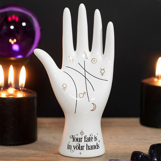 Add some mystic vibes to your space with our White Ceramic Palmistry Hand. This cool take on a classic palmistry hand features metallic gold astrology symbols representing the Sun, Moon, Venus, Mars, Jupiter, Saturn and Mercury and mystical 'Your fate is in your hands' text