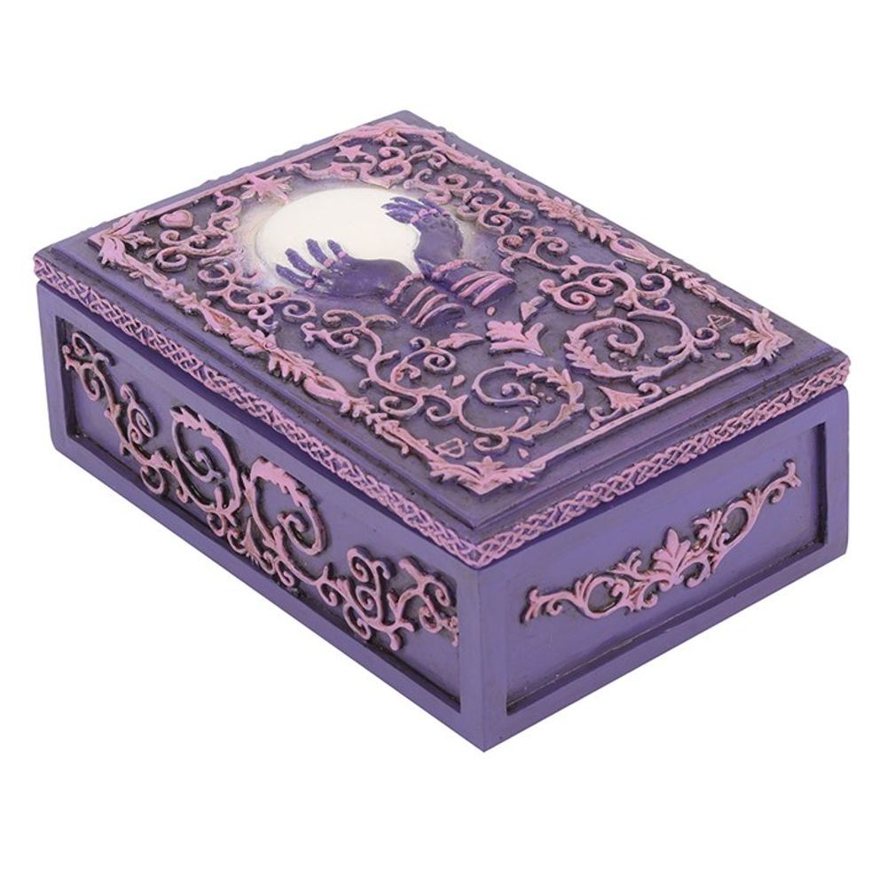 This stunning resin box features intricate filigree and a mysterious hand holding a crystal ball in the centre in pink and purple hues. Use it to store your tarot cards, crystals, herbs, and other precious objects
